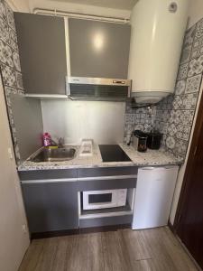 a small kitchen with a sink and a microwave at STUDIO AURON in Auron