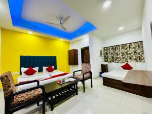 a hotel room with two beds and a table and chairs at Kanha Gold in Bhopal
