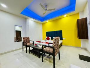 a room with a table and chairs and a yellow wall at Kanha Gold in Bhopal
