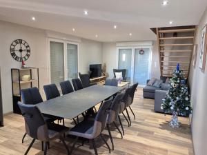 a living room with a table and a christmas tree at Maison Gite Le Randonneur in La Bresse