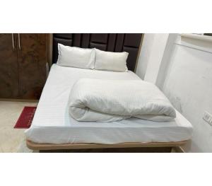 a large white bed with white sheets and pillows at Hotel Shree Nikatan in Ara
