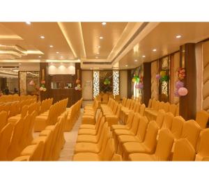 an empty auditorium with yellow chairs in a building at Hotel Shree Nikatan in Ara