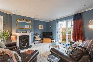 een woonkamer met een bank en een open haard bij Corner House in Deal