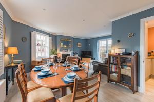 een woonkamer met een houten tafel en stoelen bij Corner House in Deal