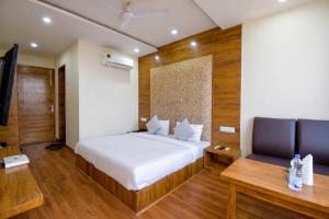 a bedroom with a white bed and a desk and a chair at Hotel Black Diamond, Patiala Chok 2 min from Zirakpur Bus Stand near Panchkula in Zirakpur
