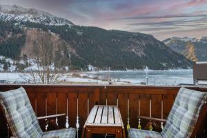 a deck with two chairs and a table and a lake at Lakeside Apartments in Haller