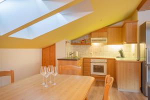 a kitchen with a wooden table with wine glasses on it at Lakeside Apartments in Haller