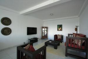 ヌワラエリヤにあるSingha Sanasa Luxury Homestayのリビングルーム(ソファ、壁掛けテレビ付)
