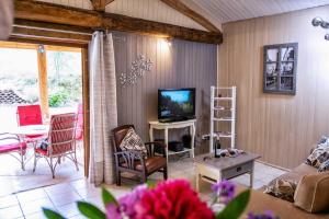 un soggiorno con un divano e una TV di Gresigne a Larroque