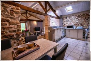 una cucina e una sala da pranzo con tavolo e sedie di Gresigne a Larroque