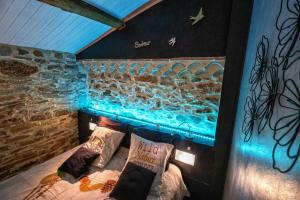 un letto in una stanza con una parete con un'illuminazione blu di Gresigne a Larroque Altre 35 foto
