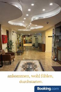 een kamer met een hal met een bank en een vloerkleed bij Airport Global Hotel in Mörfelden-Walldorf