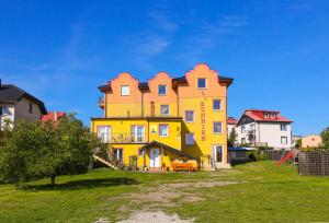 a large yellow house with a lot of windows at Apartament Margarites in Władysławowo