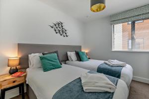 a bedroom with two beds and a table and a window at 2 Bed in Woolacombe oc-s29622 in Woolacombe +11 photos