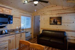 uma cozinha com um sofá de couro numa cabana de madeira em Idyllwild Camping Resort Cottage em Idyllwild