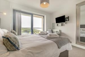 a bedroom with a large bed with a large window at 3 Bed in Woolacombe oc-t29466 in Woolacombe +24 photos
