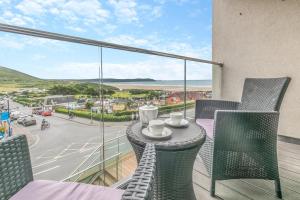 a balcony with chairs and a table with a view of a street at 3 Bed in Woolacombe oc-t29466 in Woolacombe