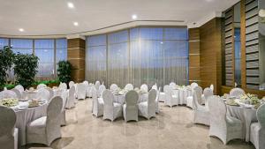 un salón de banquetes con mesas y sillas blancas en Grannos Thermal Hotel & Convention Center, en Haymana