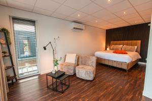 een slaapkamer met een bed en een stoel bij Tiny Boat House #3 in Garnwerd