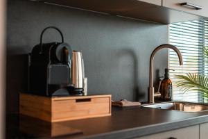 een keuken met een spoelbak en een aanrechtblad bij Tiny Boat House #3 in Garnwerd +33 foto's