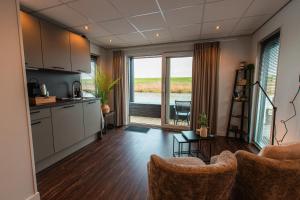 een keuken en een woonkamer met uitzicht op het water bij Tiny Boat House #3 in Garnwerd