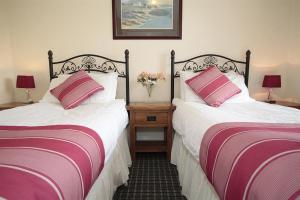 two beds in a room with pink and white sheets at 4 Bed in Port Eynon oc-hh9901 in Port-Eynon