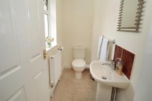 a white bathroom with a toilet and a sink at 4 Bed in Port Eynon oc-hh9901 in Port-Eynon +23 photos