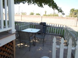 a table and chairs on a porch with a fence at Las Vegas Camping Resort Cabin 2 in Las Vegas