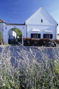 a white building with an arch in front of it at Siebenbrüderhof in Weiden am See