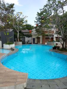 een groot blauw zwembad met bomen op de achtergrond bij WaitHozz in Beran-kidul
