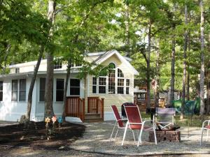 a group of chairs in front of a house at Sea Pines Loft Park Model 5 in Swainton