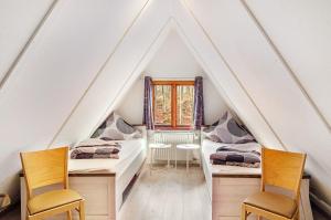 ein Zimmer mit zwei Schreibtischen und zwei Stühlen auf dem Dachboden in der Unterkunft Twistesee Ferienhaus 2 in Wetterburg