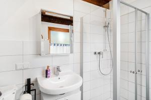 ein weißes Badezimmer mit Waschbecken und Dusche in der Unterkunft Twistesee Ferienhaus 2 in Wetterburg + 29 Fotos