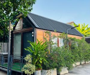 een huis met planten aan de zijkant bij JJ Palace เจเจ พาเลซ in Ban Si Than