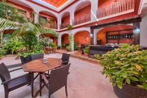 a restaurant with a table and chairs and plants at Hotel Pozo Rey by Youroom in Chipiona
