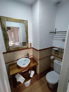 a bathroom with a sink and a toilet and a mirror at Hotel Pozo Rey by Youroom in Chipiona +3 photos
