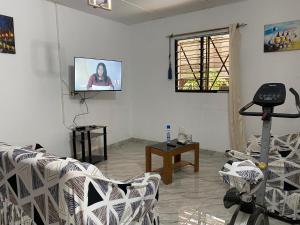 a living room with a tv on a wall at Lege Bonoua in Bonoua +4 photos