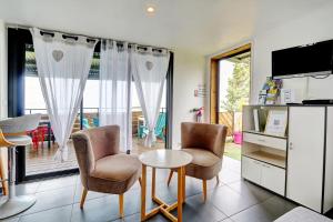 een woonkamer met twee stoelen en een tafel bij Les Gites Le Bambou - 3 étoiles - Les Avirons in Les Avirons