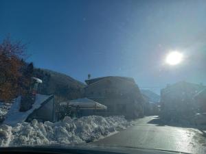 a street covered in snow with the sun in the background at Casa Bisalta relax in San Bartolomeo