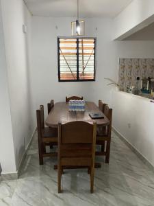 a dining room with a wooden table and chairs at Lege Bonoua in Bonoua