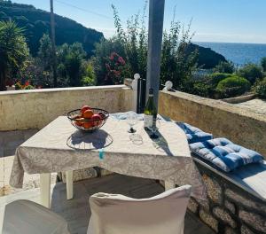 a table with a bowl of fruit and a bottle of wine at Mani Beach House in Vathia