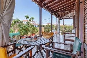 a patio with a wooden table and chairs at Studios Galini in Skopelos Town
