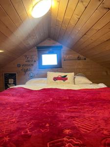 een bed met een rood dekbed in een kamer bij Czerwony Kominek in Lutek +16 foto's