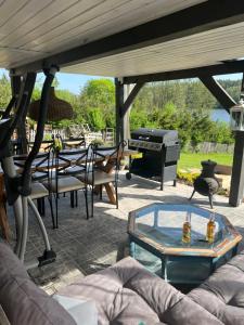 een patio met een tafel en een grill bij Czerwony Kominek in Lutek