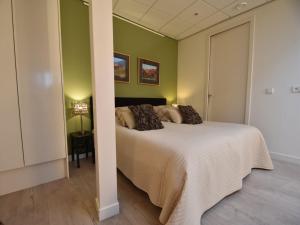 ein Schlafzimmer mit einem großen Bett mit grünen Wänden in der Unterkunft Alluring Apartment in Bergen with Terrace, Garden and BBQ in Bergen