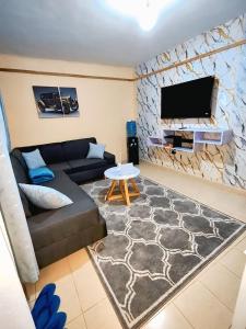 ein Wohnzimmer mit Sofa und Flachbildfernseher in der Unterkunft Smiley Stay in Nakuru