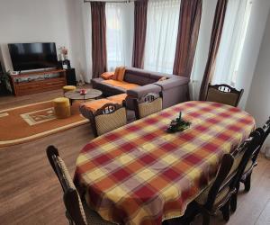 een woonkamer met een tafel en een bank bij Casa CLO in Sighetu Marmaţiei +10 foto's