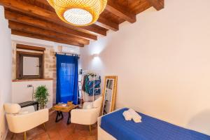 a bedroom with a bed and chairs and a table at Elsa d'Ortigia - I Tre Archi in Syracuse