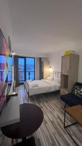 a hotel room with two beds and a flat screen tv at Gudauri Loft Apartment N508 in Kʼumlistsʼikhe