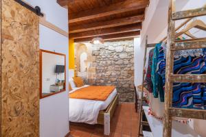 a bedroom with a bed in a room with a stone wall at Elsa d'Ortigia - I Tre Archi in Syracuse